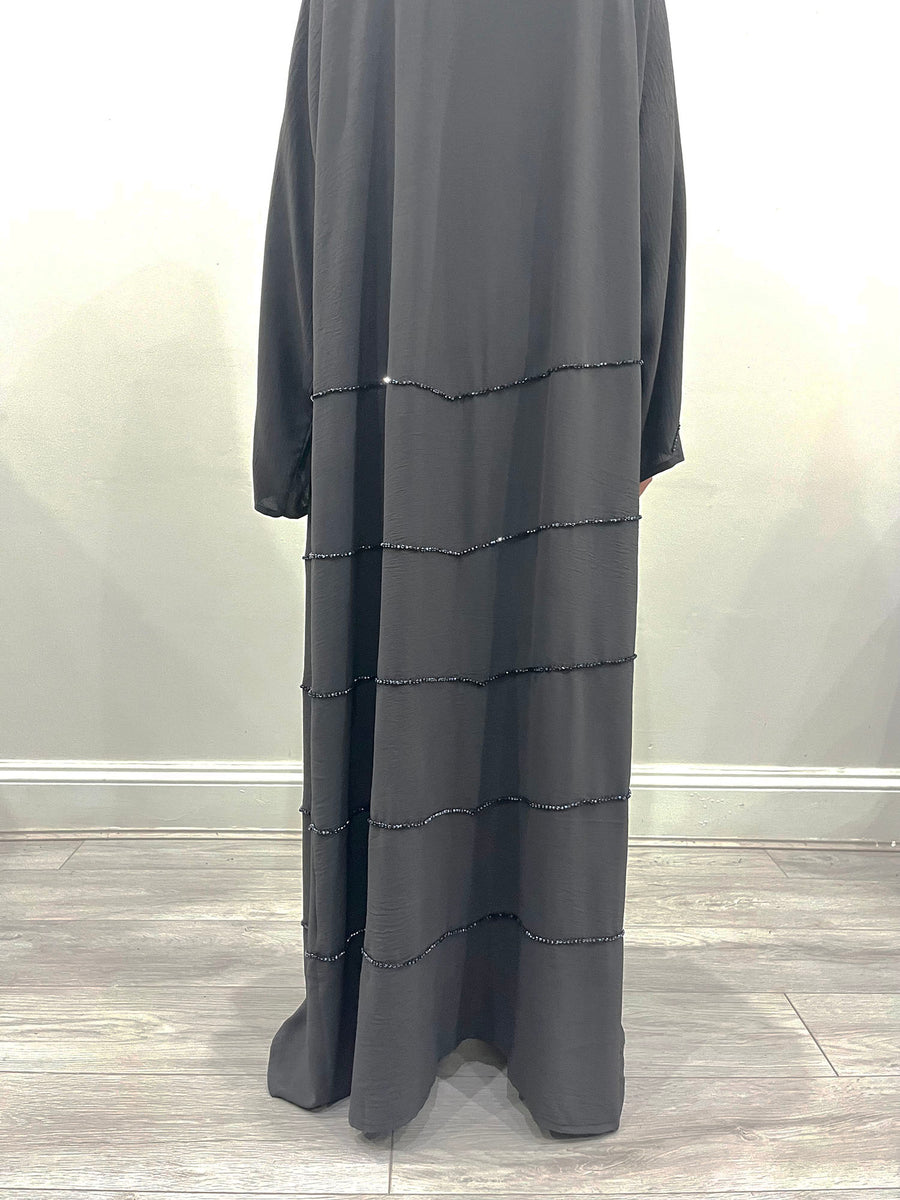 Charcoal grey abaya shown with its matching hijab and belt
