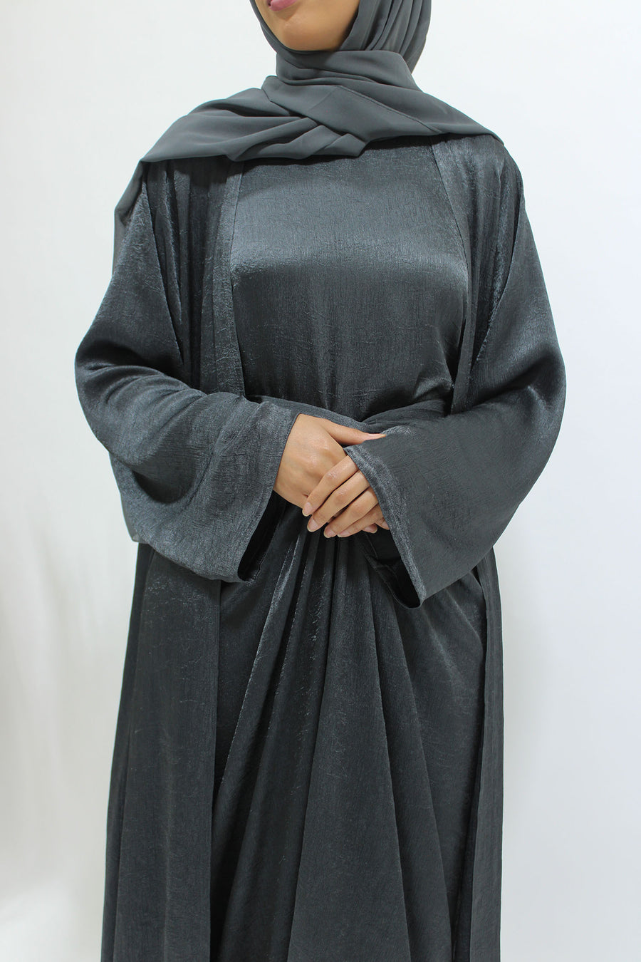 Side view of the anchor grey crushed satin open abaya showing its smoky textured sheen