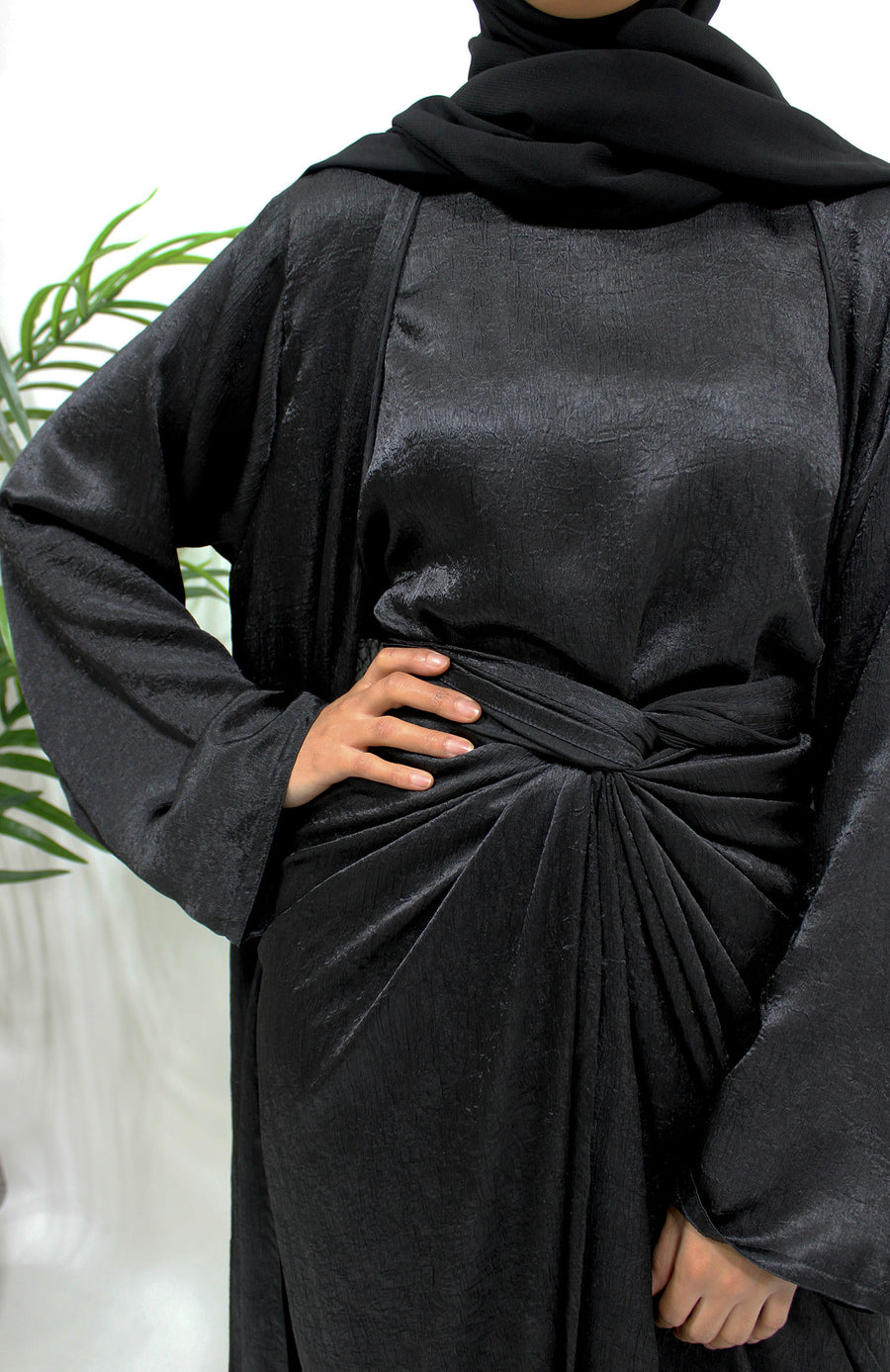 Side view of the black crushed satin open abaya showing the kimono drape and soft textured sheen
