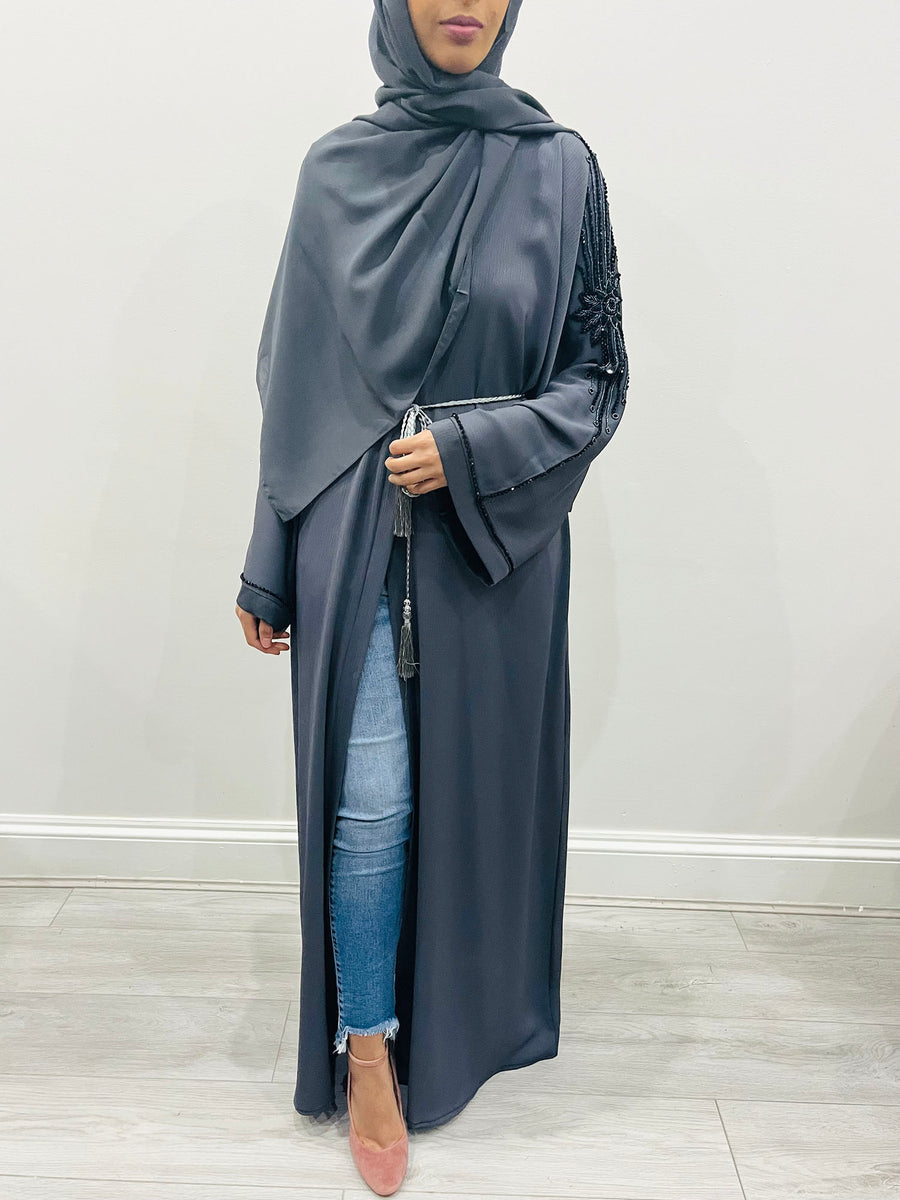 Close-up of the hand-stitched beadwork on the slate gray abaya arms