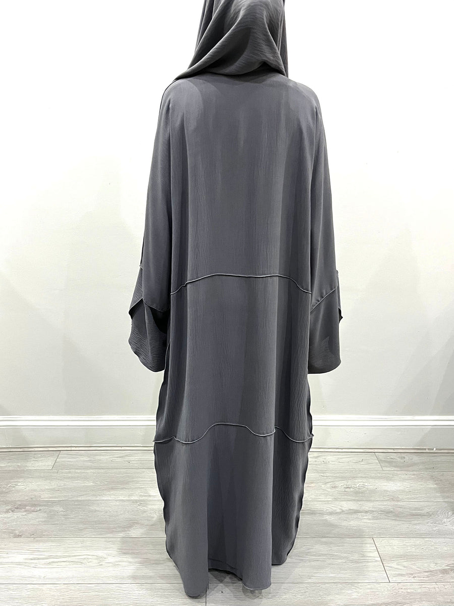 Side view of the slate gray open abaya showing its drape