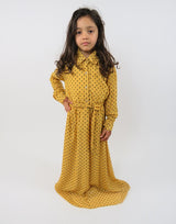 Girl wearing Amani's mustard yellow and black polka-dot long-sleeve kids maxi dress