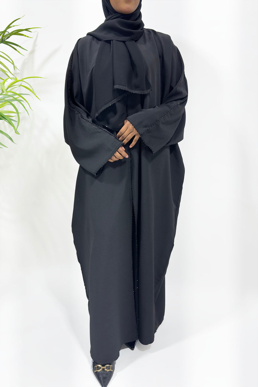 Side view of the ash black open abaya showing its soft drape