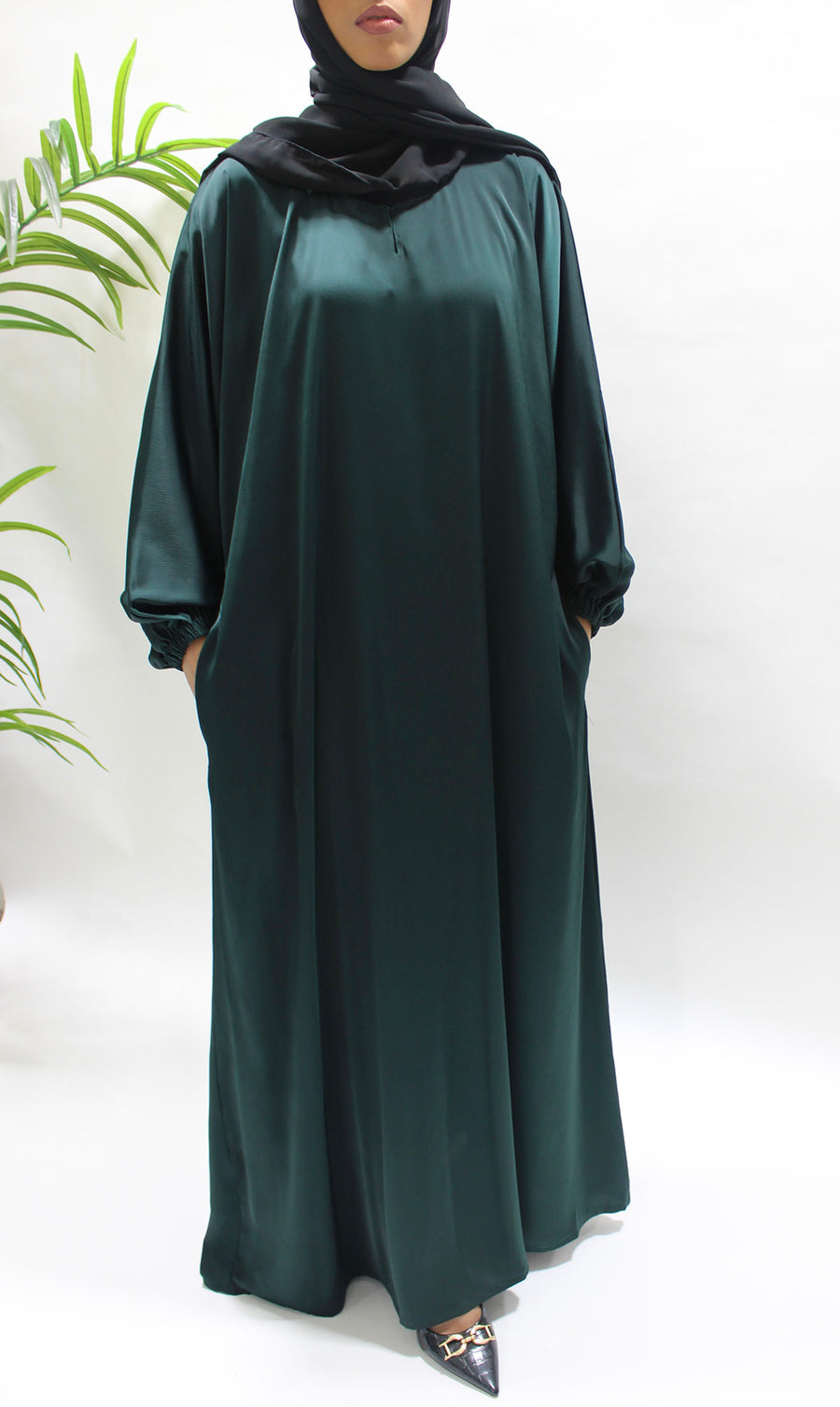 Textured satin fabric detail on the bottle green abaya