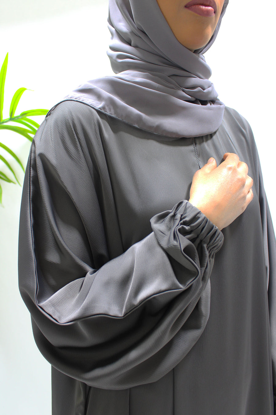 Full-length view of Amani's dark taupe textured satin abaya