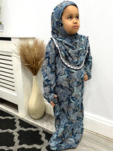 Little girl wearing Amani's floral print slip-on prayer dress with attached hijab
