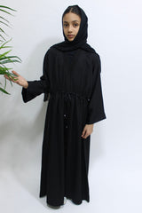 Girl wearing Amani's black draw string abaya with matching scarf