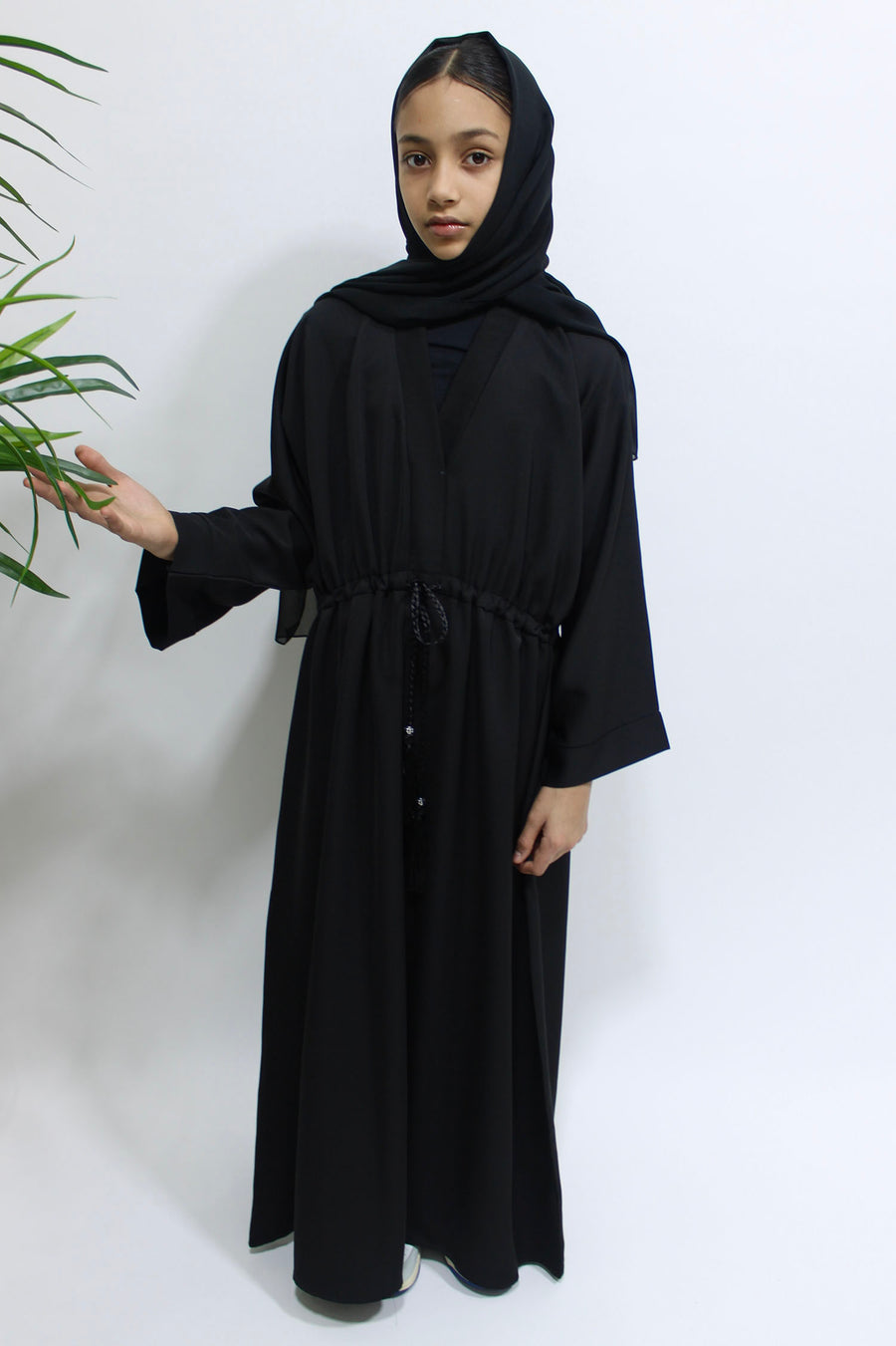 Girl wearing Amani's black draw string abaya with matching scarf