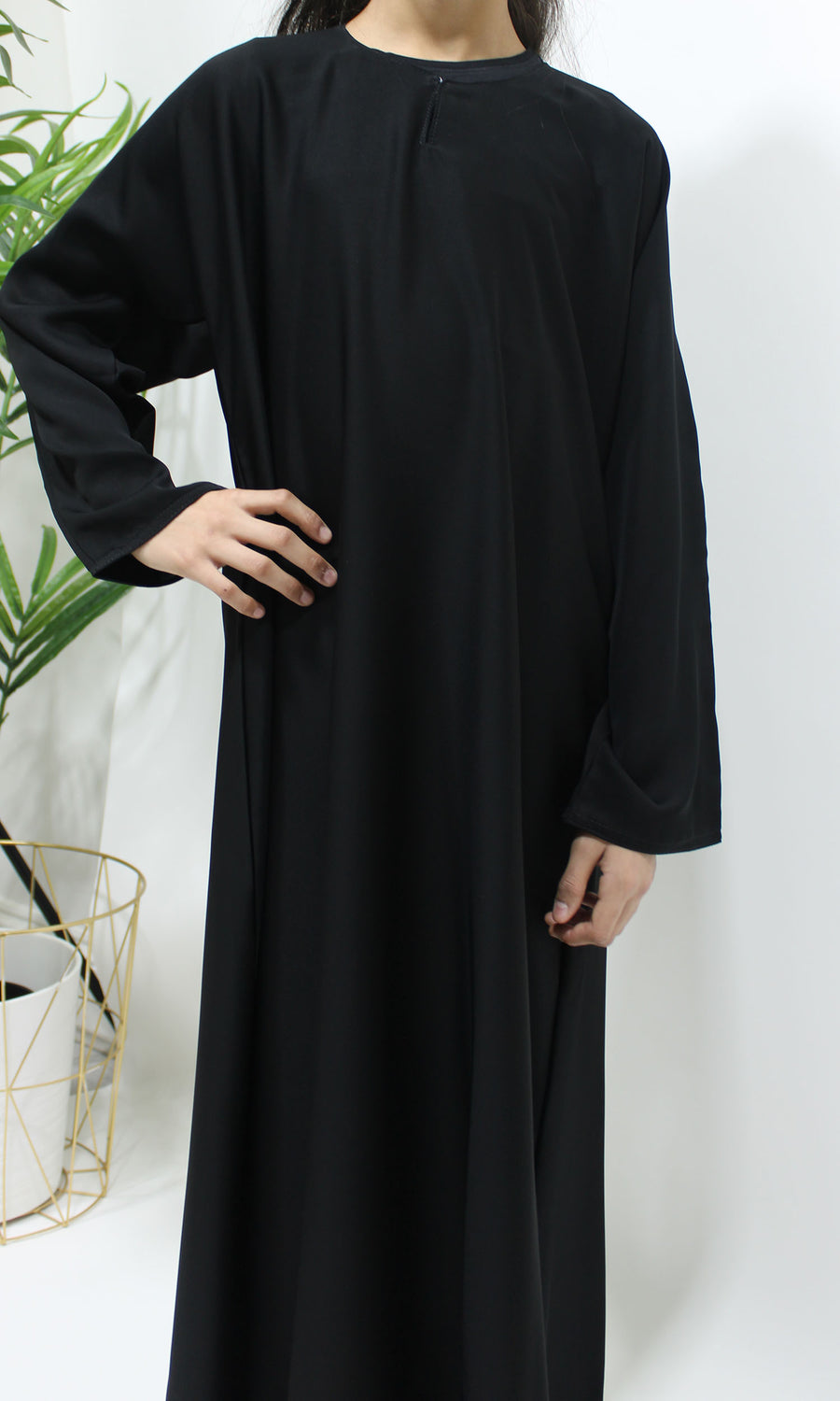 Girl wearing Amani's plain black Neda abaya, front view
