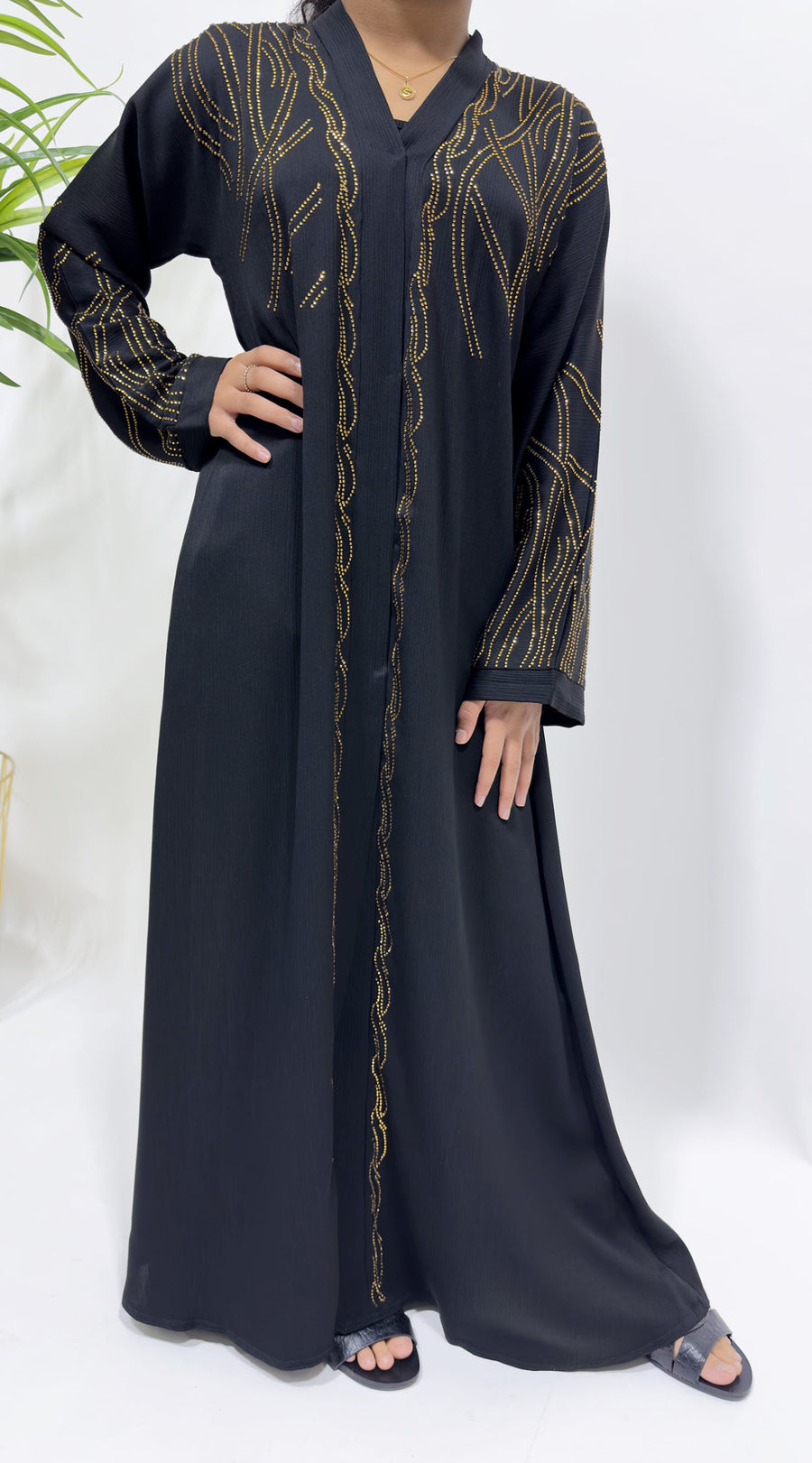 Girl wearing Amani's black gold embellished open abaya with scarf