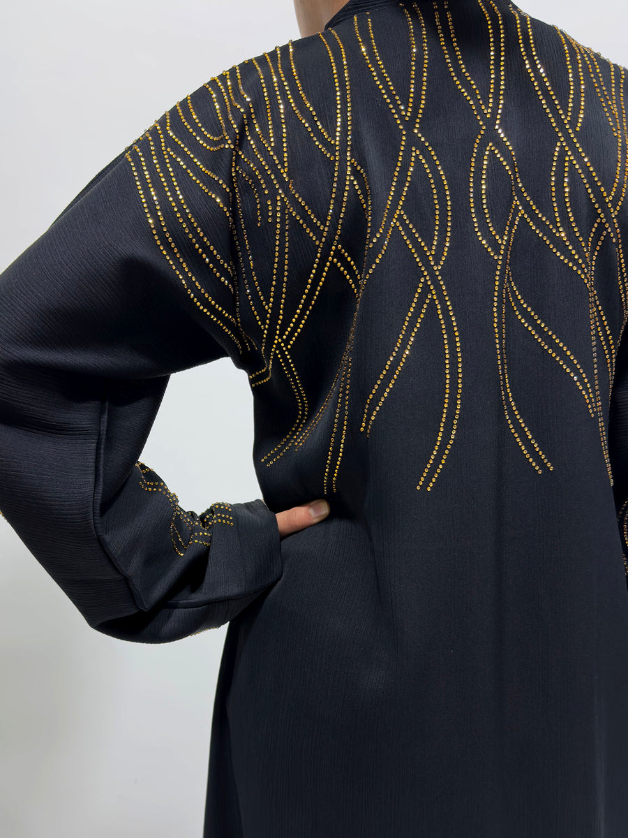 Gold diamante stone detail on the black girls' open abaya