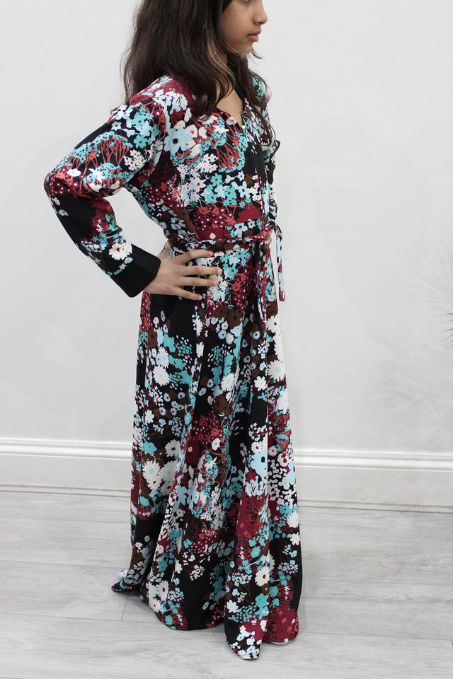 Girl wearing Amani's burgundy floral umbrella-cut kids maxi dress