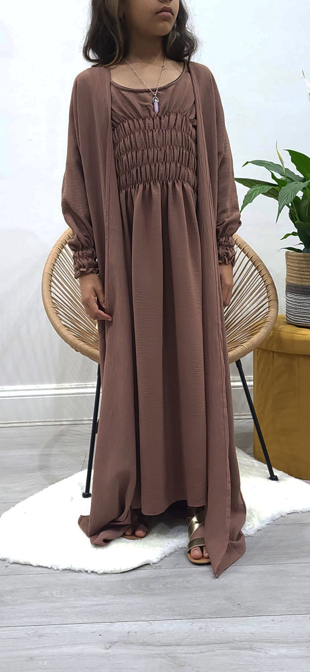 Girl wearing Amani's russett brown jacket-style abaya set with belt and scarf