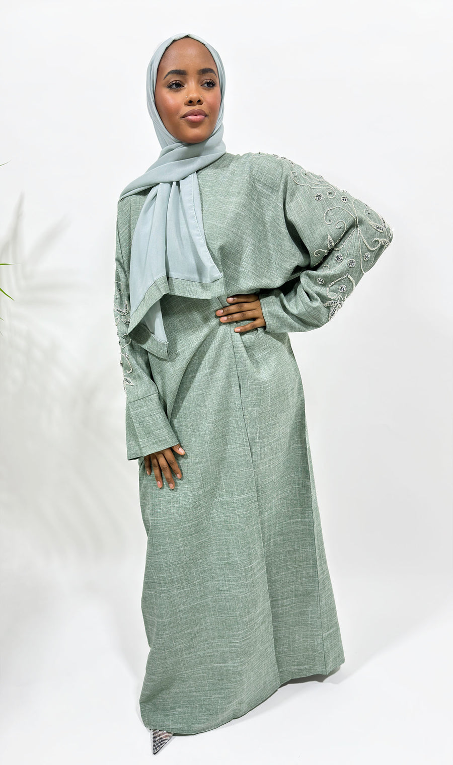 Hand-stitched sleeve embellishment on the greenish grey linen blend bisht abaya