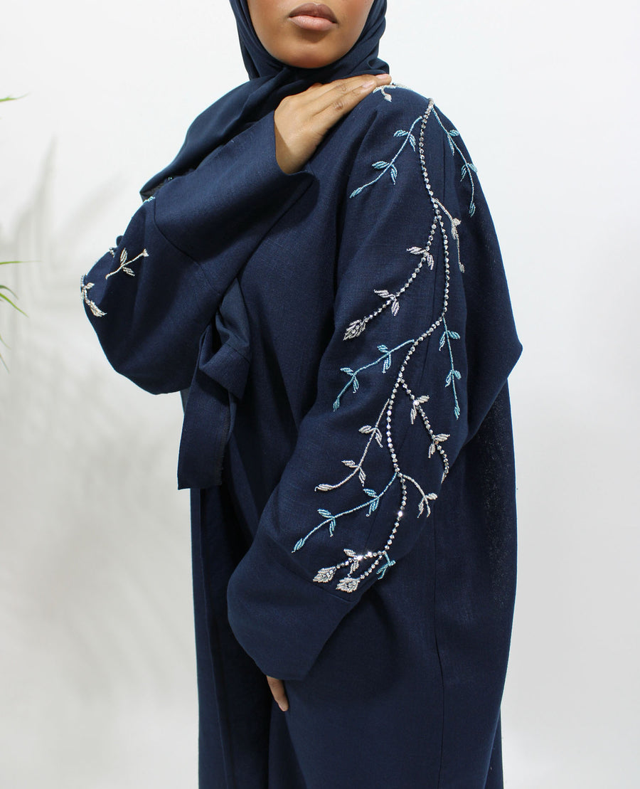 Hand-stitched sleeve embellishment on the navy blue linen blend bisht abaya