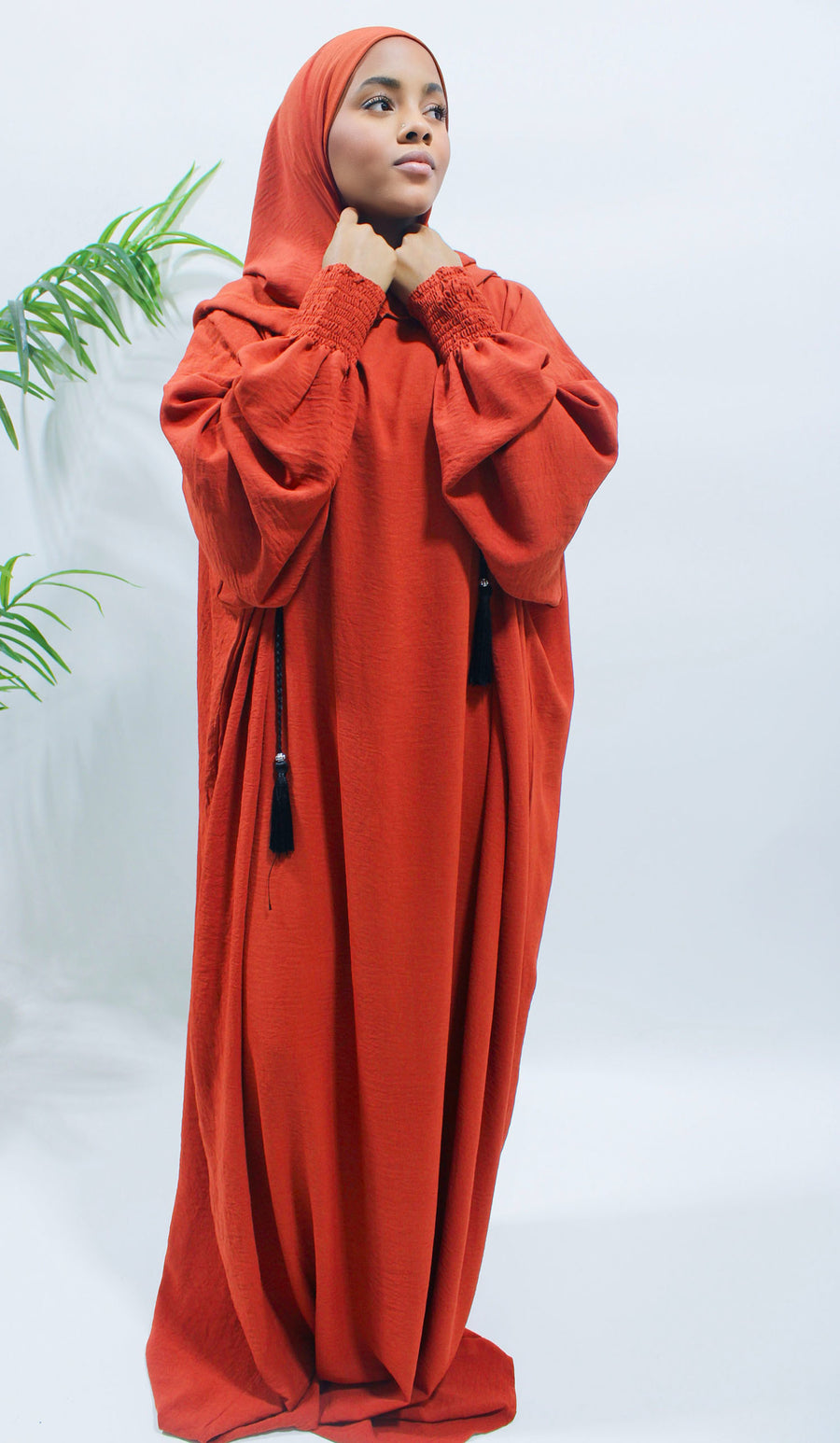 Close view of the ruched cuff on the orange red prayer abaya