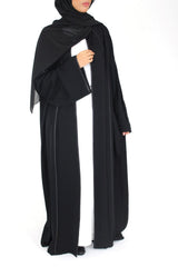 Woman wearing Amani's black open abaya with satin piping and matching scarf