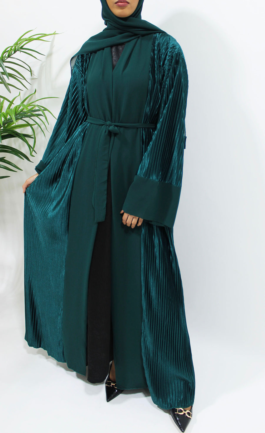 Side view of the green teal pleated satin open abaya showing the vertical pleats and soft sheen