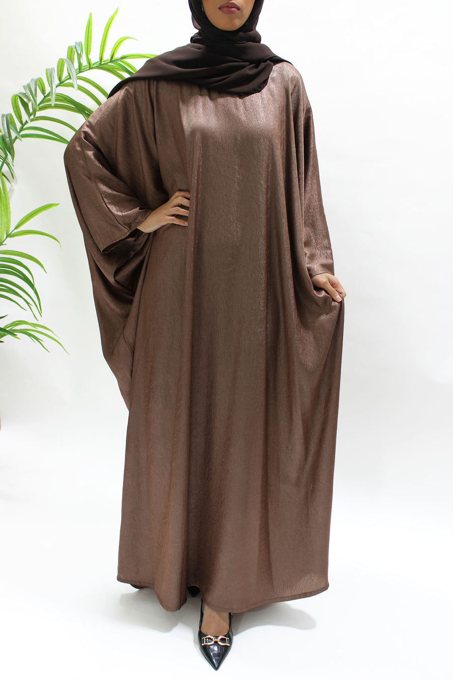 Side view of the brown farasha abaya showing its flowing drape