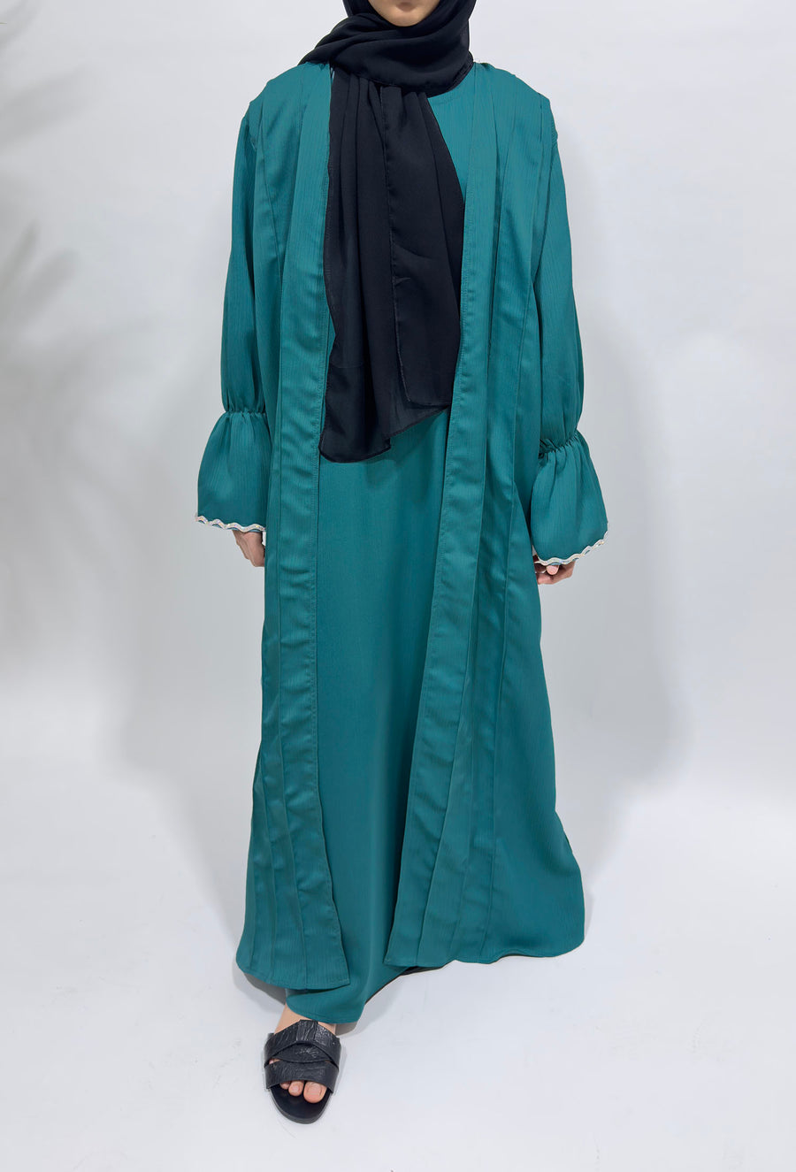 Girl wearing Amani's turquoise two piece style open abaya with scarf