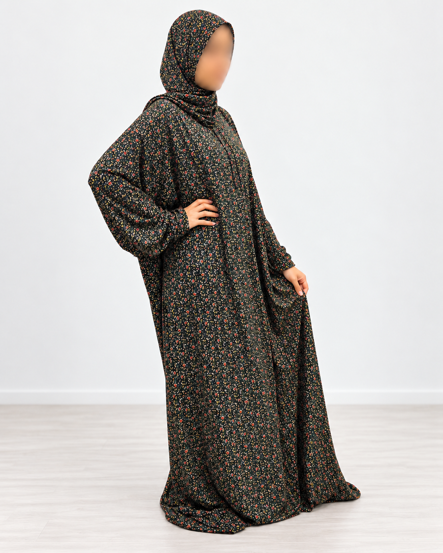Side-angled full-length view of the black floral prayer dress showing the flowing silhouette and printed sleeves