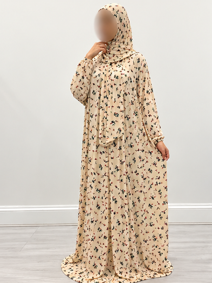 Amani's buttermilk floral one-piece prayer dress with attached wrap-around hijab, front three-quarter view, narrow elastic cuffs and no lace