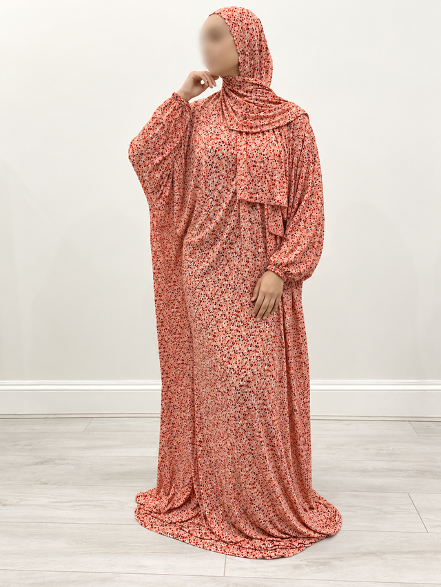 Coral floral one-piece prayer dress with attached wrap-around hijab, full-length front view and narrow elastic cuffs.