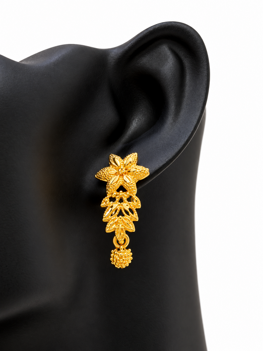 Close-up of matching golden floral leaf drop earring