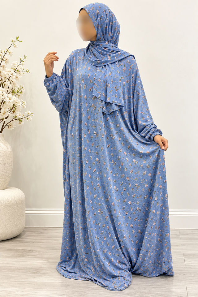 Amani's powder blue floral one-piece prayer dress without lace, full-length front three-quarter view, attached wrap-around hijab and narrow elastic cuffs