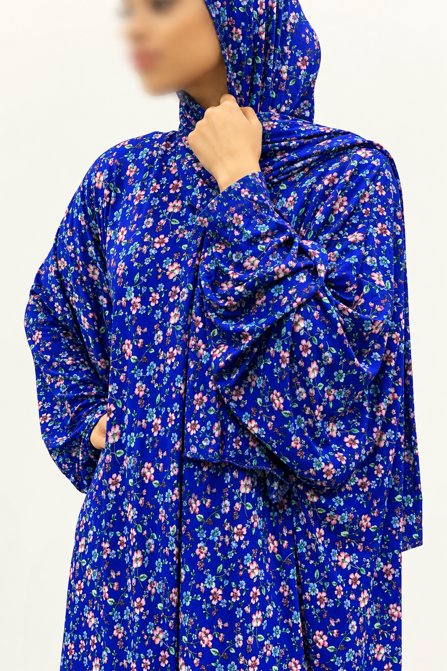 Close-up of royal blue prayer dress and wrap-around hijab, showing pink and green floral print and no white lace trim