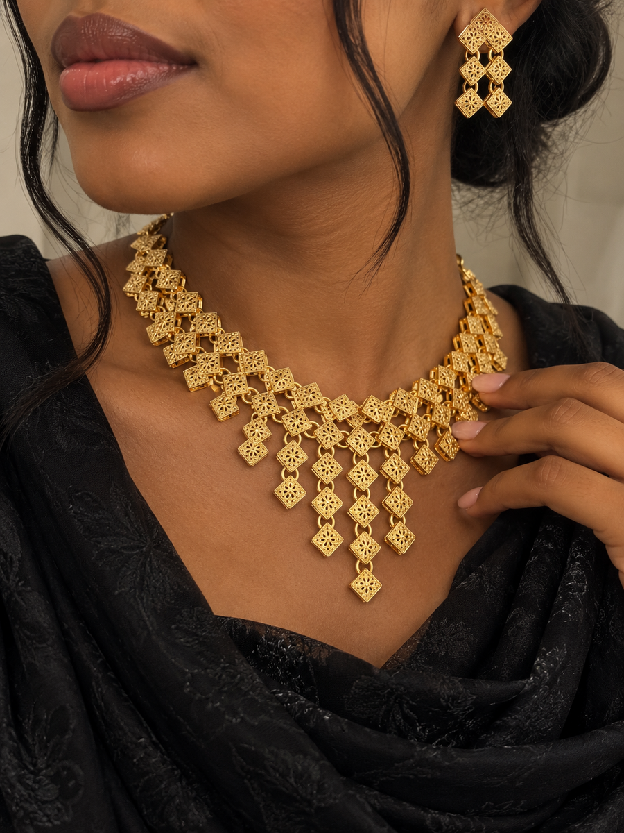 Model wearing gold-tone geometric filigree cascade necklace and earrings
