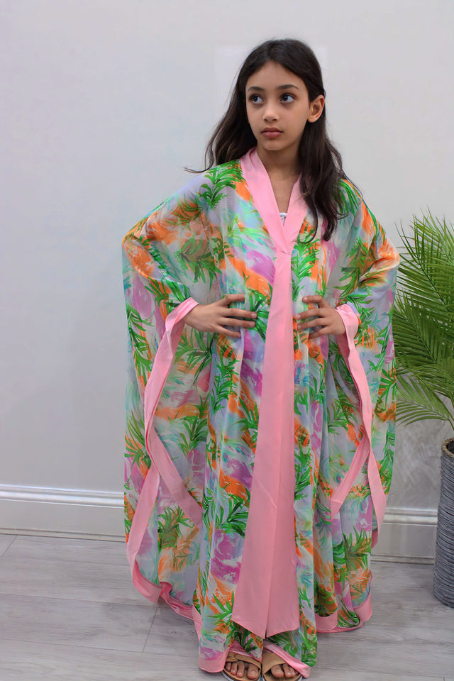 Girl wearing Amani's pink floral chiffon kids kaftan over an undergarment