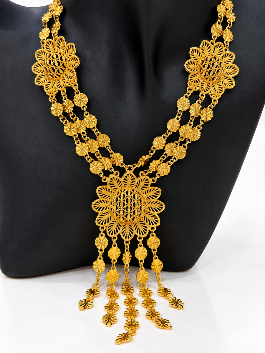 Close-up of gold-tone sunburst medallion necklace with layered drop details